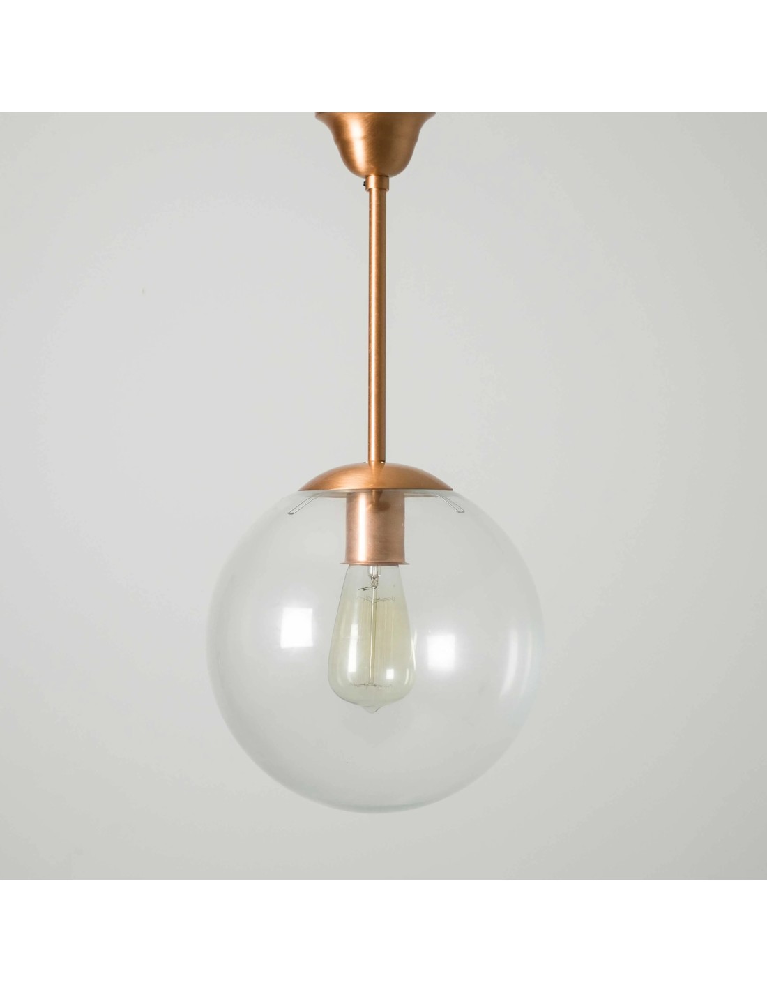 lámpara vintage con una bola de cristal transparente con acabado cobre brillante en la tija y en el soporte.