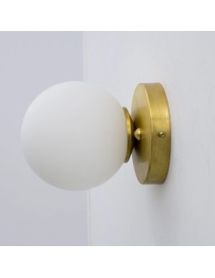 vintage wall sconce asymmetrically holds a glass ball in opal white. 2