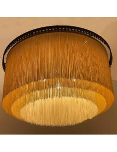 Detail of a pendant lamp with yellow fringe and a decorative classic-style metal ring. 2