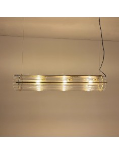 Linear glass and brass pendant lamp with warm lighting.